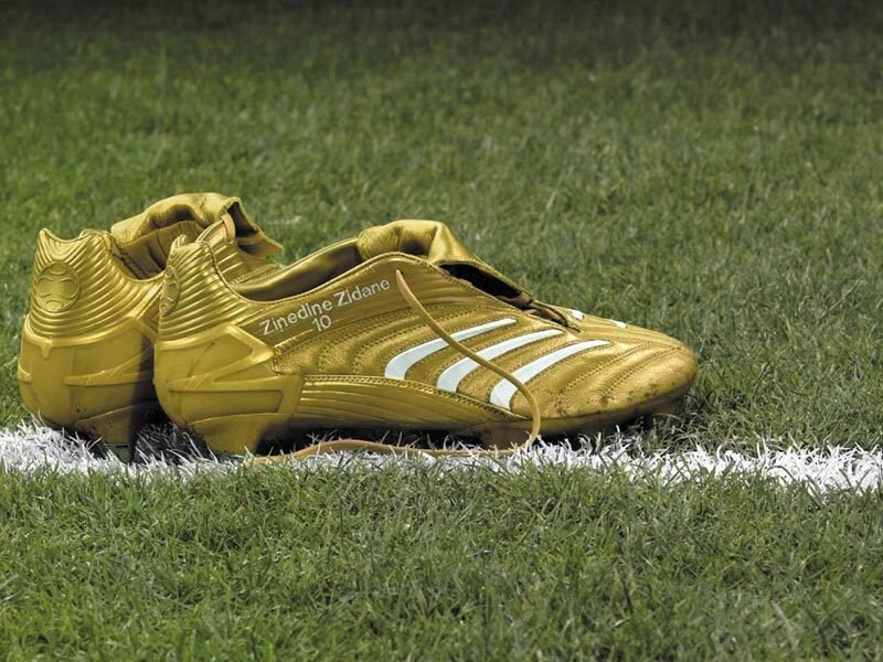 golden soccer cleats on grass
