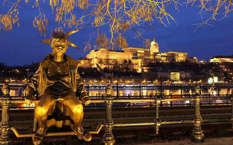 Golden statue by the river at night