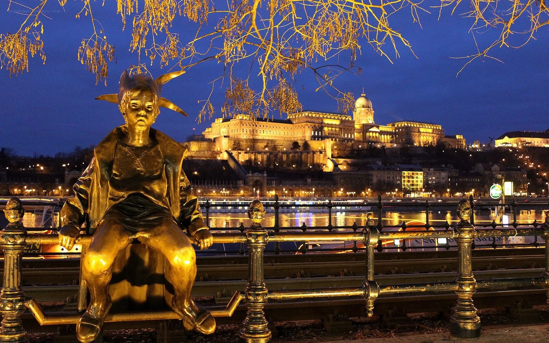 Golden statue by the river at night