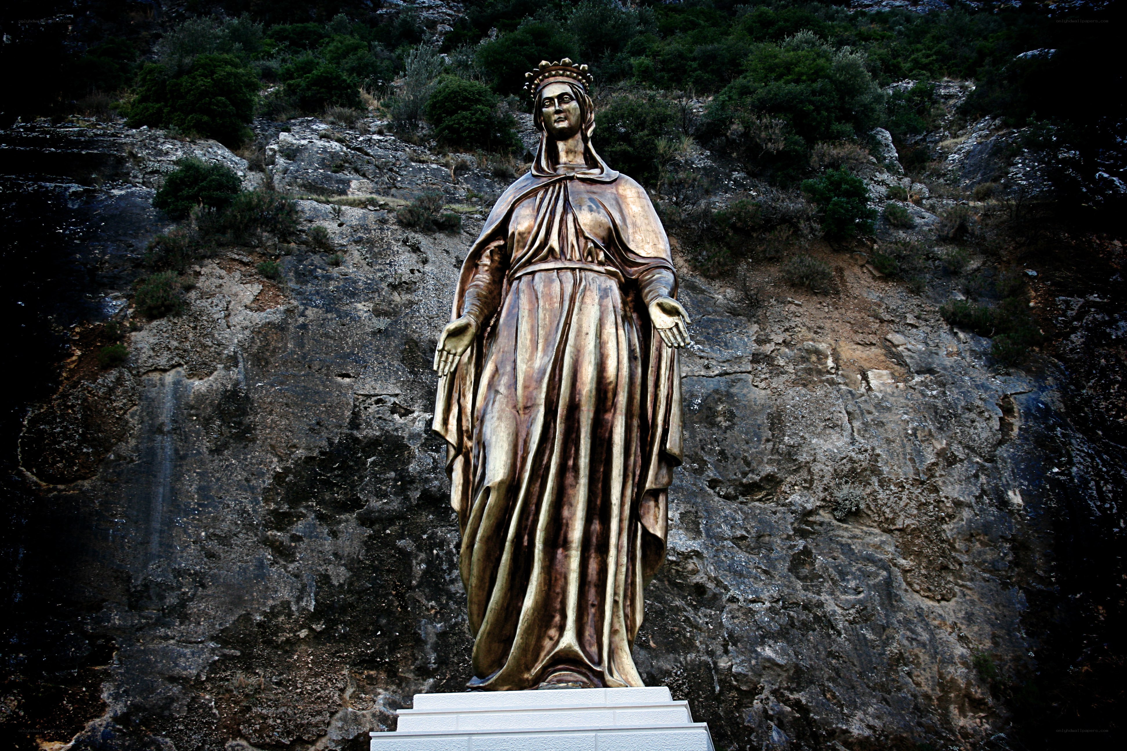 Golden statue on rocky hillside