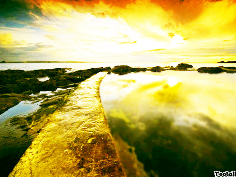 Golden sunset over rocky shore