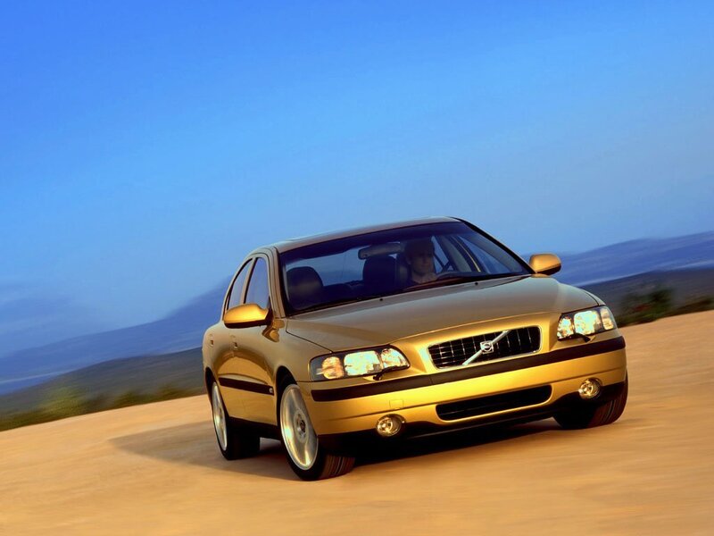 golden volvo on a coastal road
