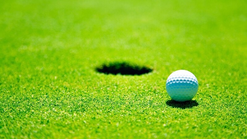 Golf ball near hole on green
