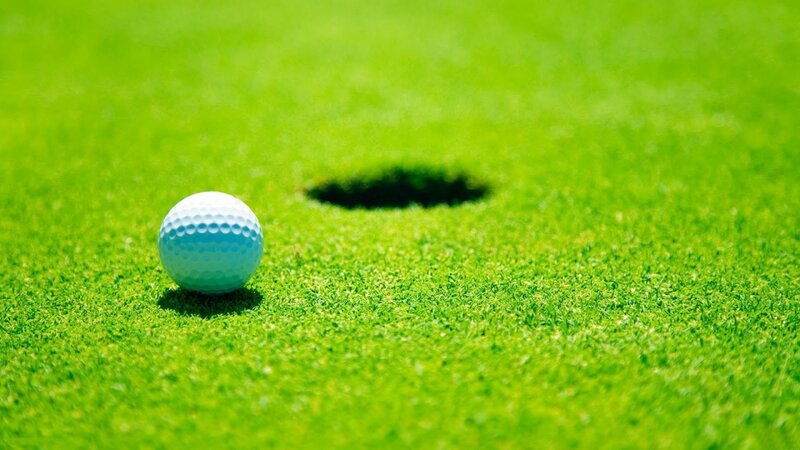 Golf ball near hole on green
