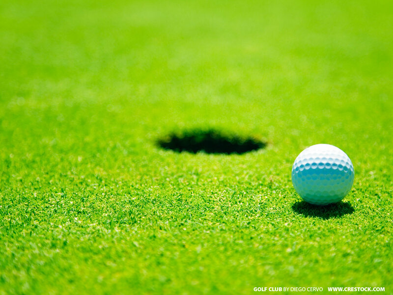 golf ball near hole on green