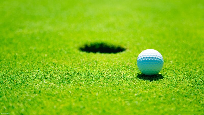 Golf ball on green near hole