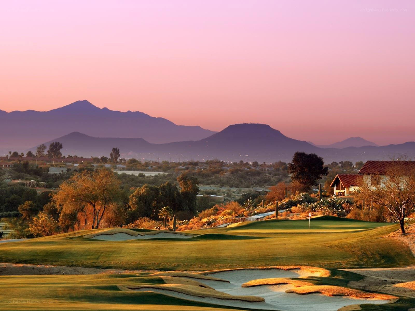 Golf course at sunset with mountains