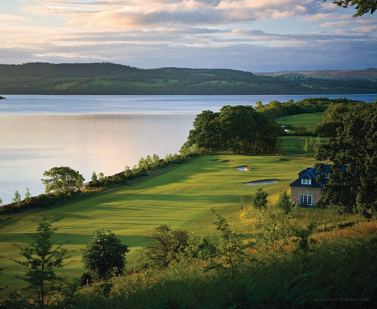 Golf course by a lake at sunset