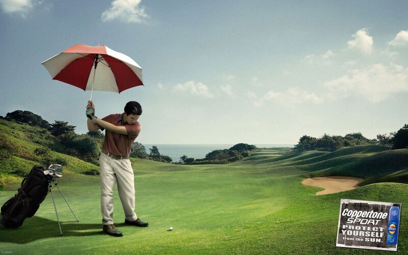 Golfer with umbrella on course