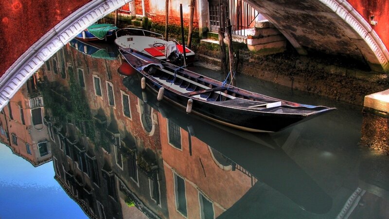 Gondola under a bridge in Venice