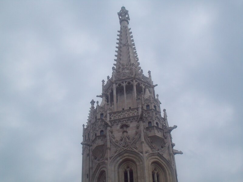 Gothic spire against cloudy sky