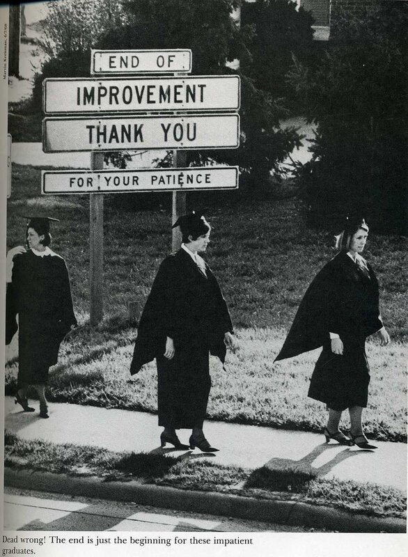 graduates near road sign