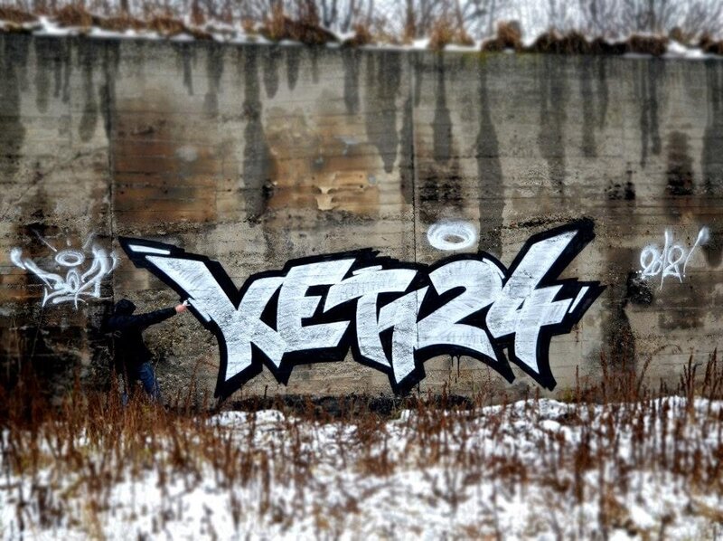 graffiti artist painting on concrete wall