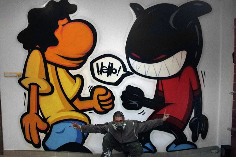 Graffiti artist with cartoon mural