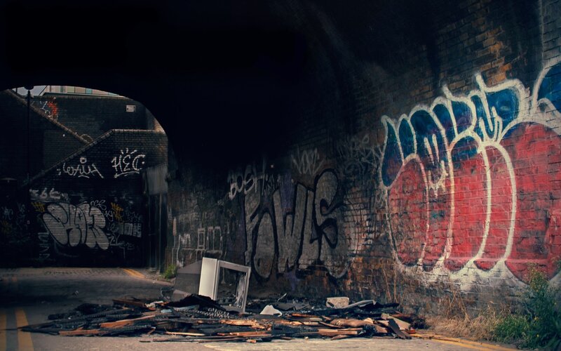 graffiti-covered alley under bridge