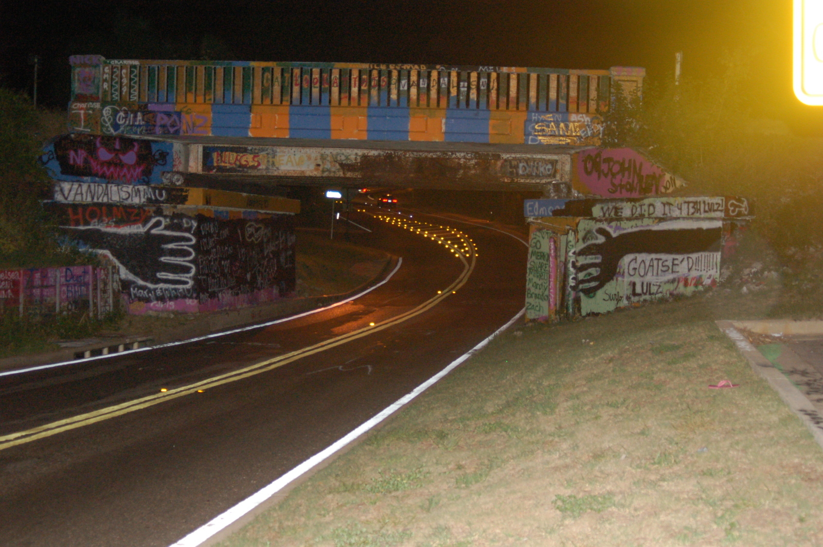 graffiti-covered bridge at night