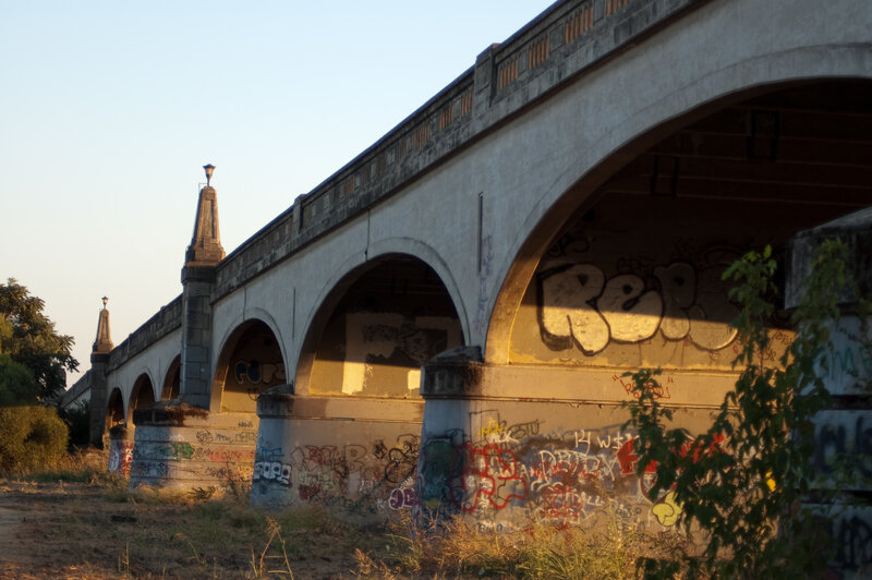 Graffiti-covered bridge at sunset