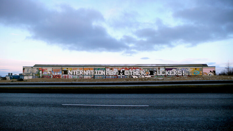 graffiti-covered building with offensive text