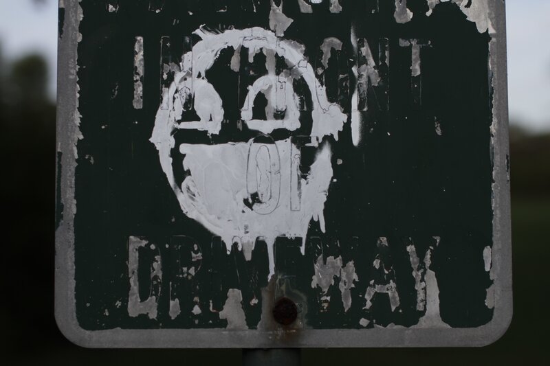 graffiti-covered driveway sign