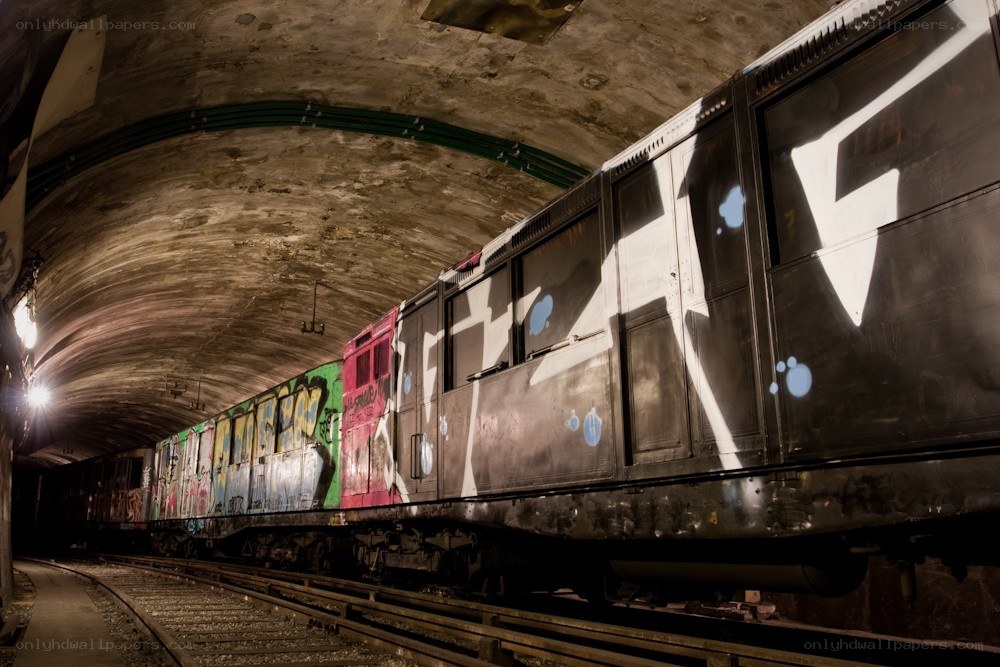 graffiti-covered train in subway tunnel