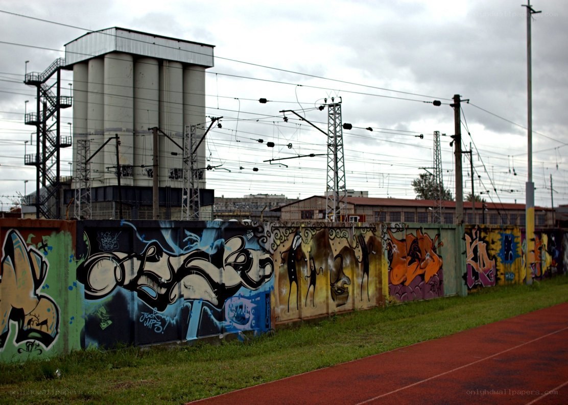 Graffiti-covered wall near train tracks