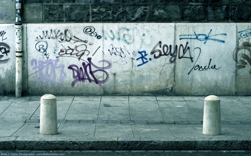 graffiti-covered wall on sidewalk
