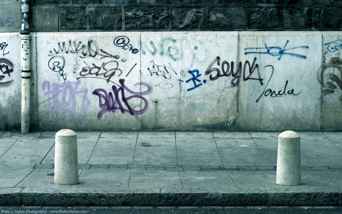 graffiti-covered wall on sidewalk