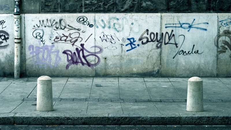 graffiti-covered wall on sidewalk