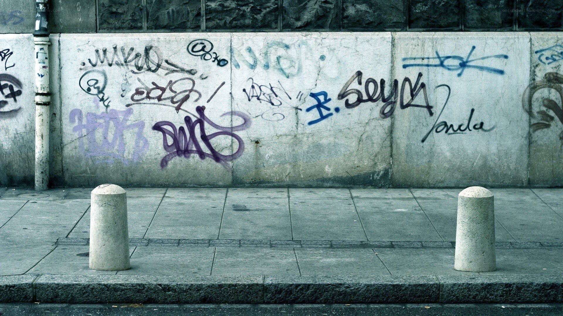graffiti-covered wall on sidewalk