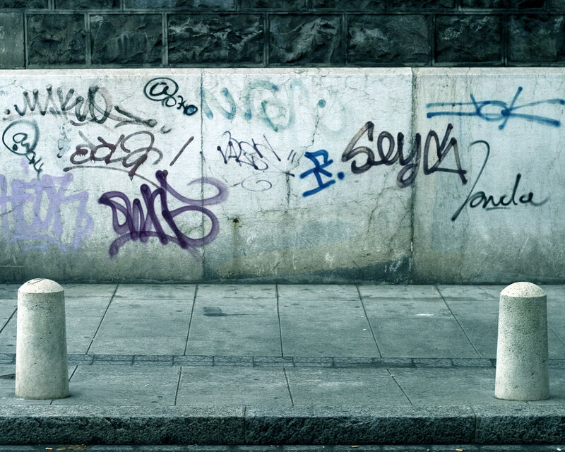 graffiti-covered wall on sidewalk