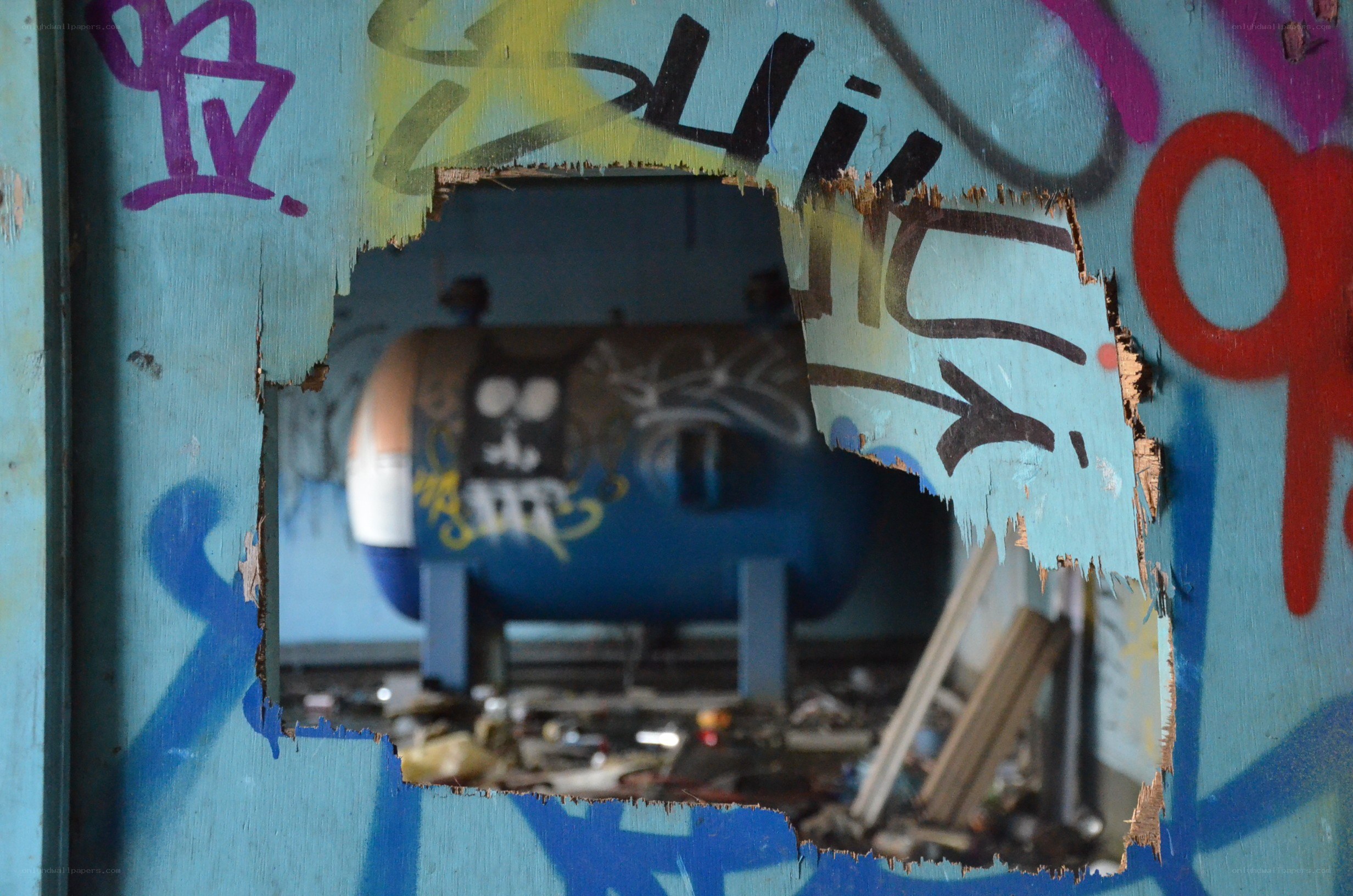 graffiti-covered wall with hole