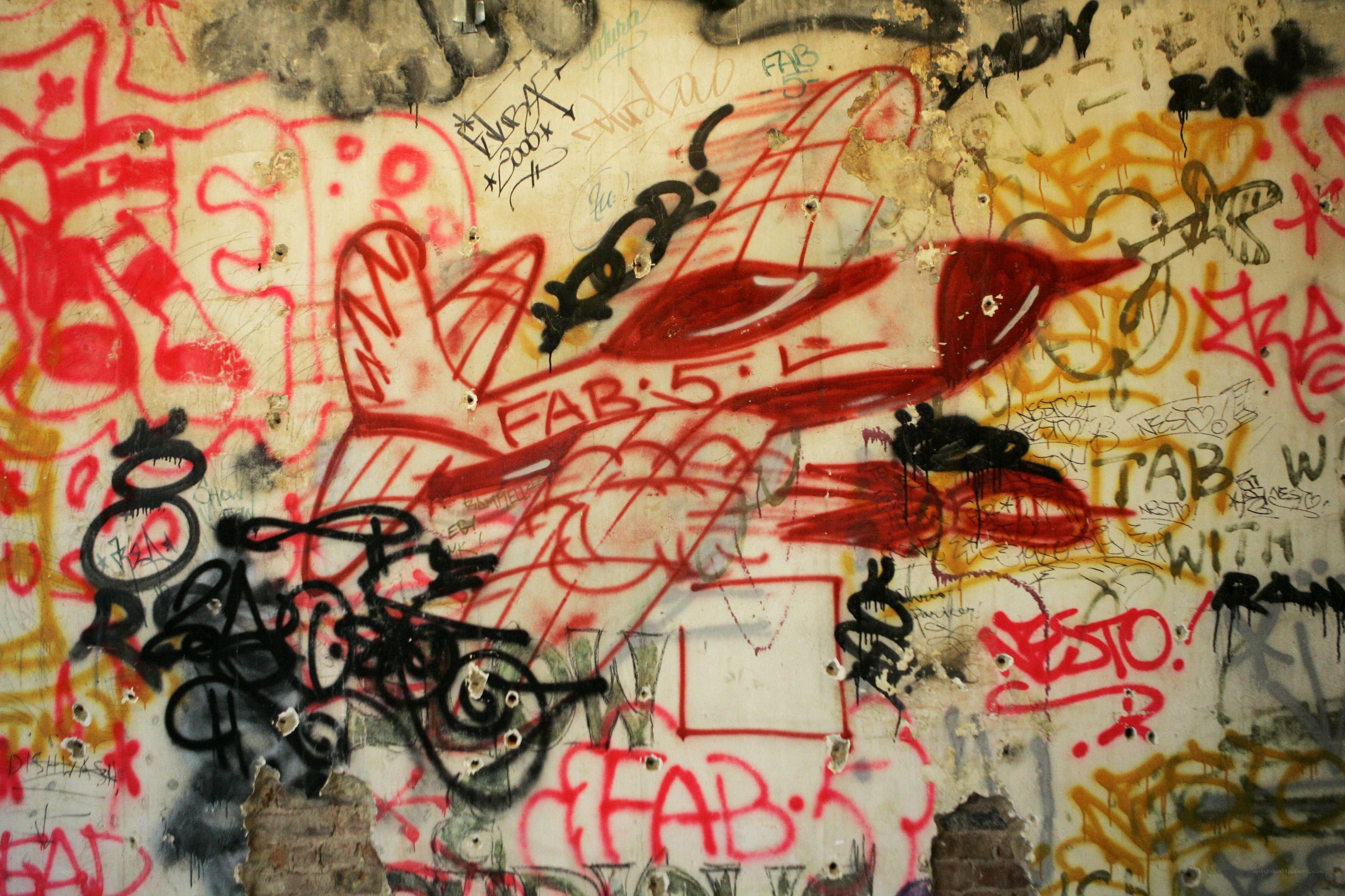 graffiti-covered wall with red airplane