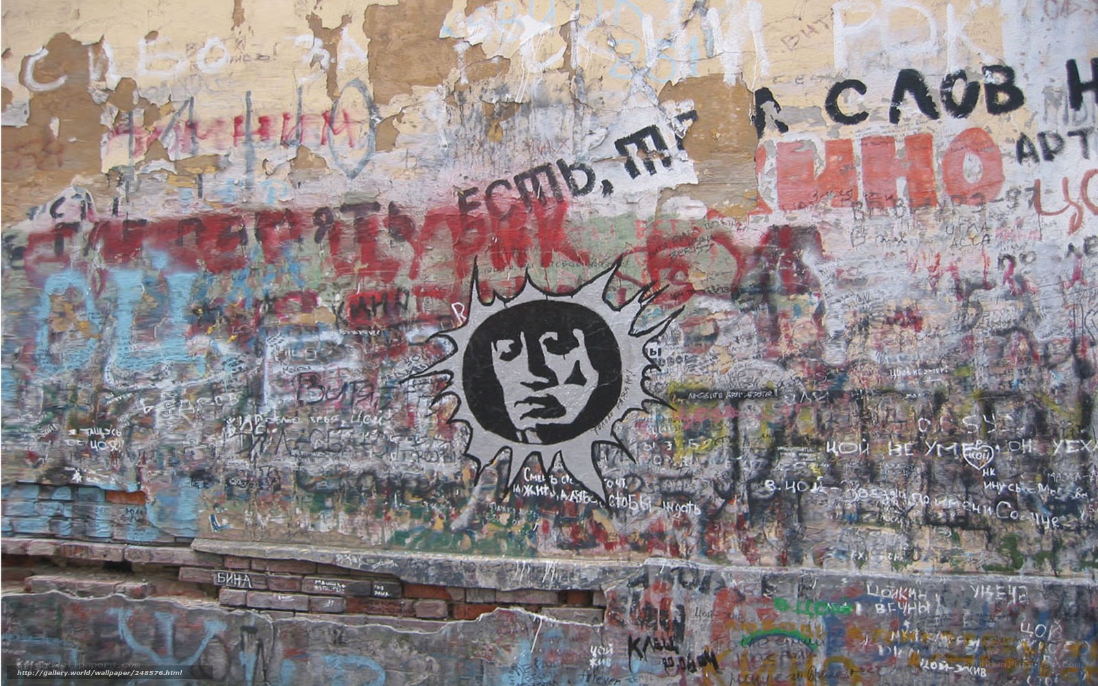 graffiti-covered wall with sun symbol