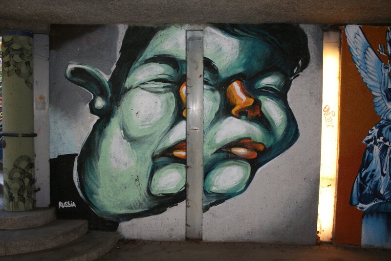 graffiti of a face under a bridge