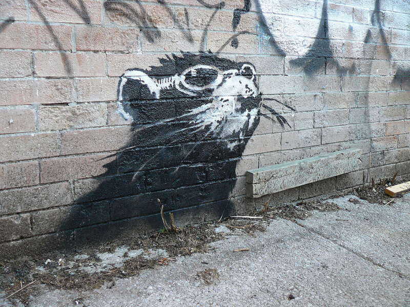 graffiti of a rat on brick wall