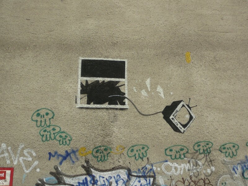 Graffiti of TV breaking through wall