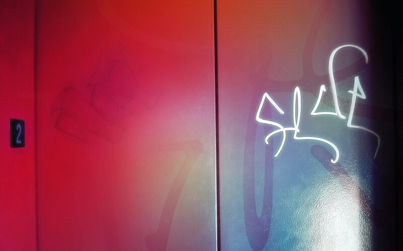 graffiti on red elevator doors
