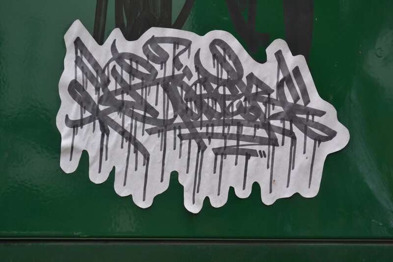 graffiti sticker on green surface