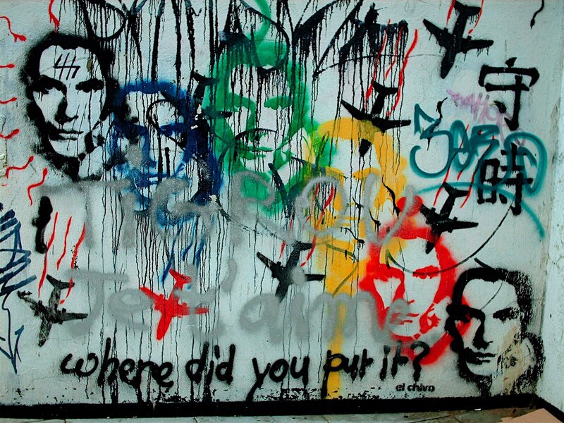 graffiti wall with faces and text