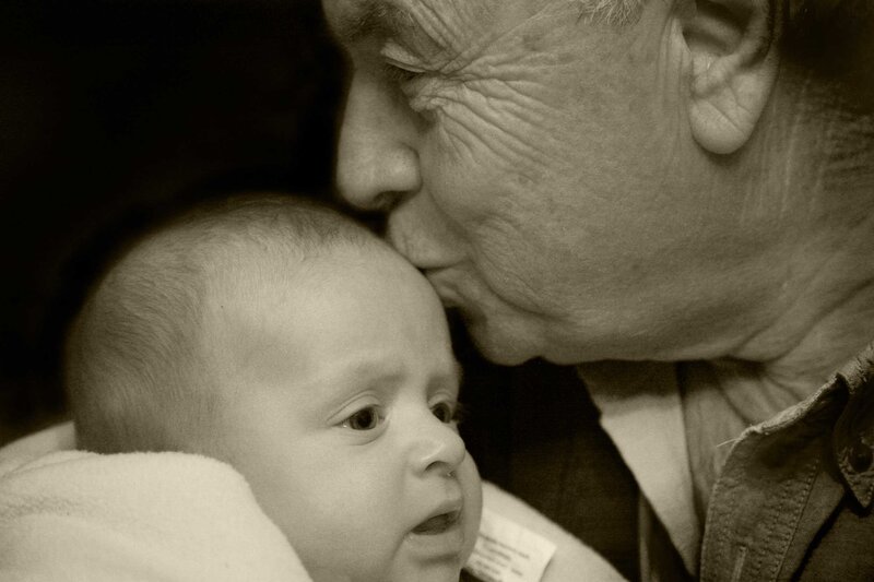 grandfather kissing baby