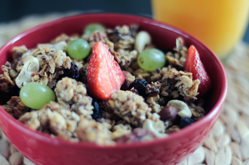 granola with fruit in red bowl