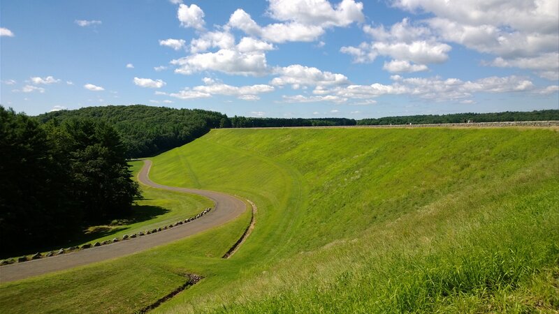 Grassy dam with winding road