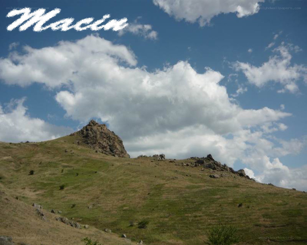 Grassy hill with rocky peak