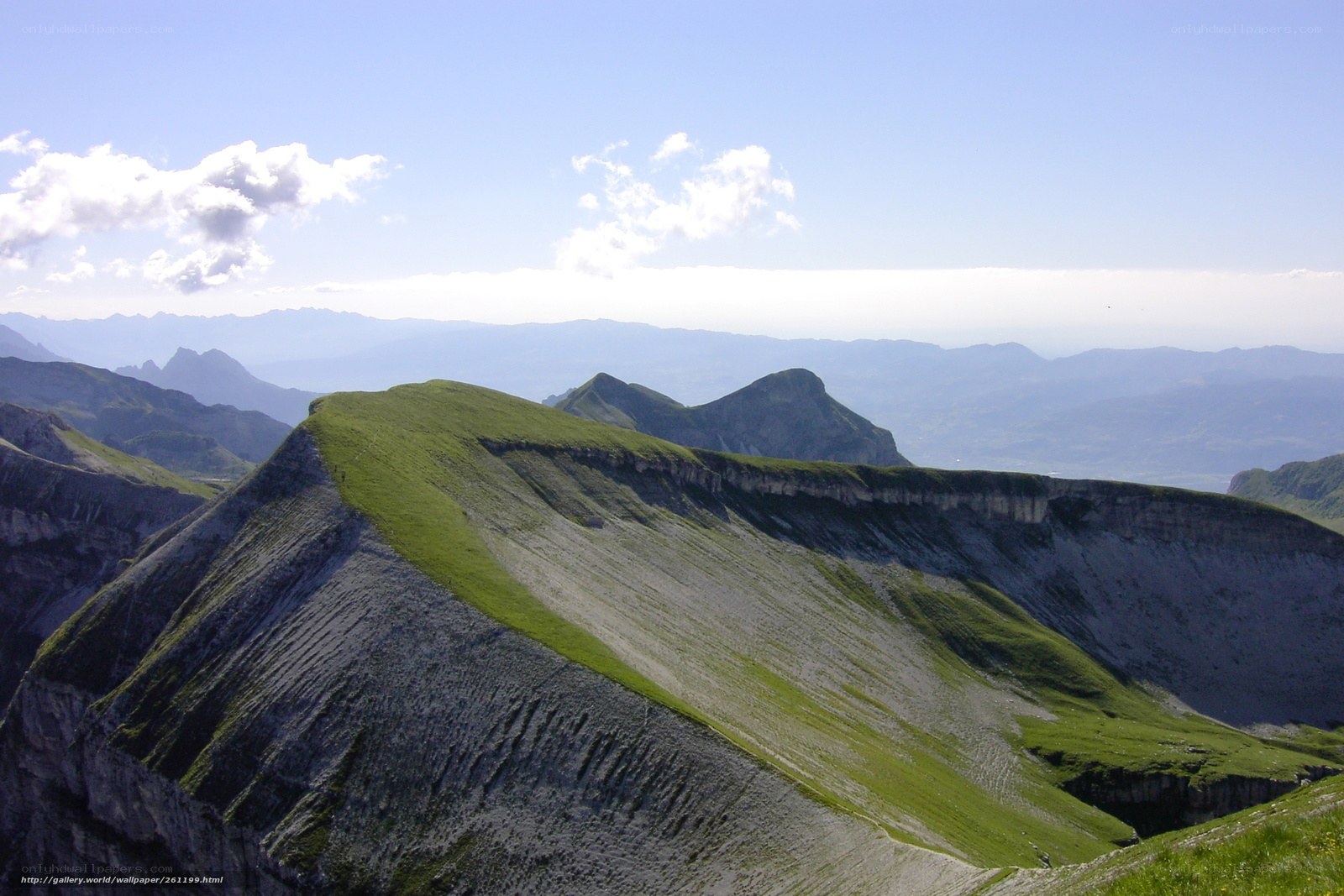 Grassy mountain ridge under blue sky