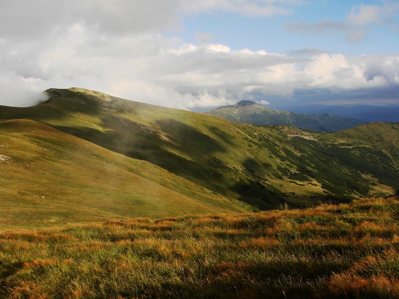 Grassy mountain slopes under cloudy sky