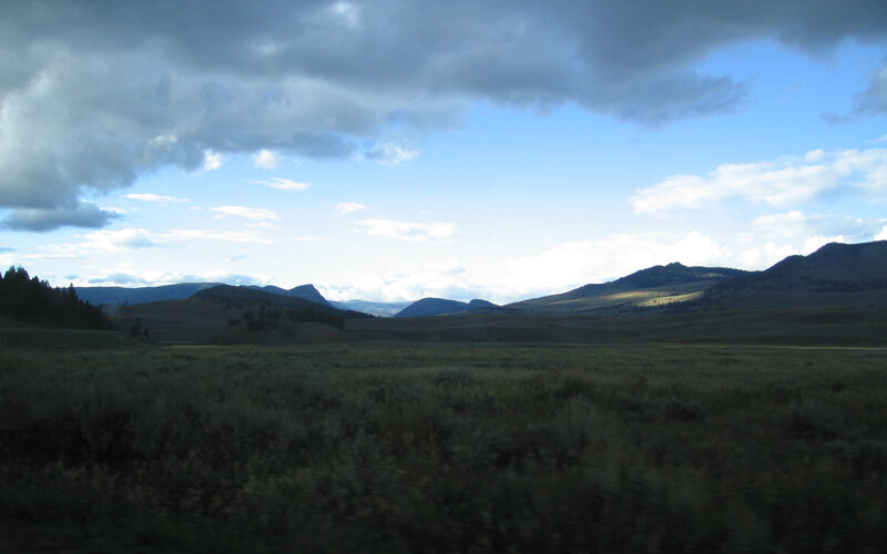 Grassy plains under cloudy sky