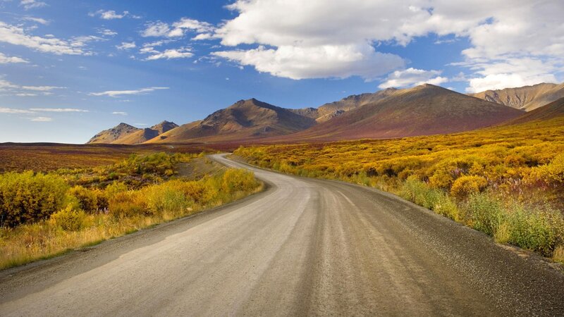 Gravel road through autumn mountains