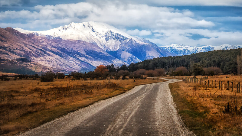 Gravel road to snow-capped mountains