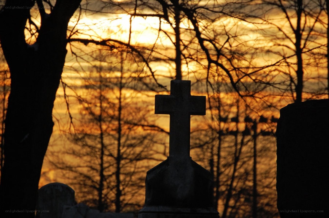 Graveyard cross at sunset