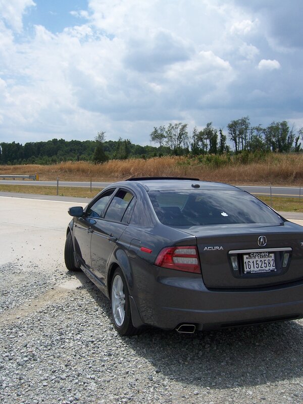 Gray Acura parked on gravel